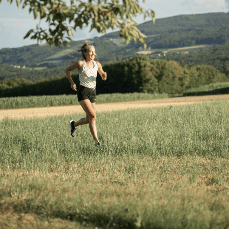 Läuferin beim individuellen Lauftraining auf einer Laufbahn mit persönlichem Coach